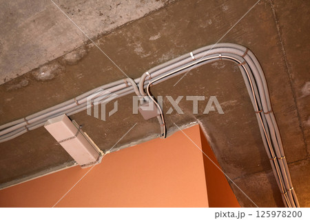 Installation of electrical wiring on the ceiling. 125978200