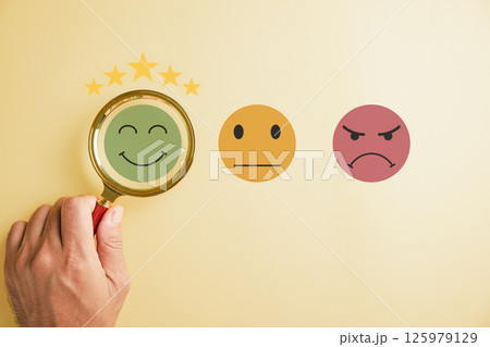 Magnifying glass held by hand selects happy smiley face icon among emotions. Good feedback rating, positive customer review. Experience, satisfaction survey, mental health concept. satisfaction. Magnifying glass held by hand selects happy smiley face icon among emotions. Good feedback rating, positive customer review. Experience, satisfaction survey, mental health concept. satisfaction. 125979129
