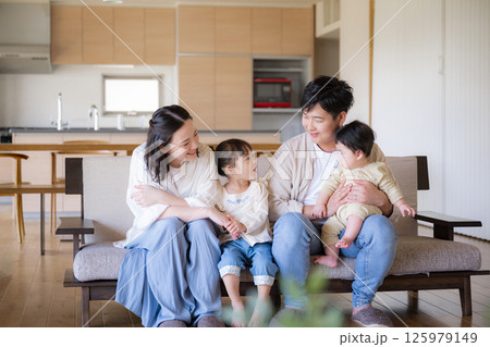木のぬくもりのある新築のような家の自宅のソファーでくつろぐ4人の日本人家族 木のぬくもりのある新築のような家の自宅のソファーでくつろぐ4人の日本人家族 125979149