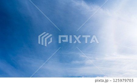 澄み渡る青空に広がる薄雲と太陽の神秘的な光環「ハロ現象」 澄み渡る青空に広がる薄雲と太陽の神秘的な光環「ハロ現象」 125979703