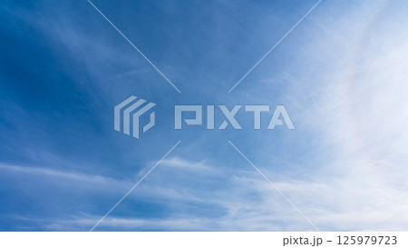 澄み渡る青空に広がる薄雲と太陽の神秘的な光環「ハロ現象」 125979723