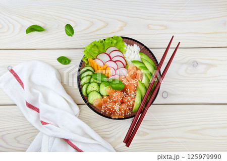 Poke bowl with salmon, rice, radish, carrot, cucumber. Hawaiian ahi, a diet meal with fish. Poke bowl with salmon, rice, radish, carrot, cucumber. Hawaiian ahi, a diet meal with fish. 125979990