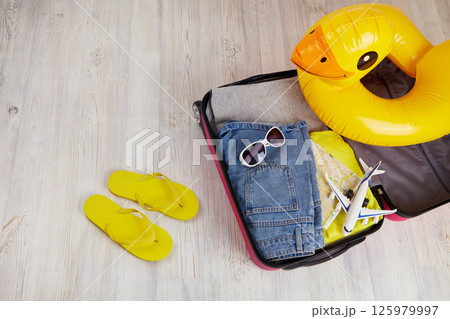 Suitcase with clothes and leisure accessories. Summer travel. Suitcase with clothes and leisure accessories. Summer travel. 125979997