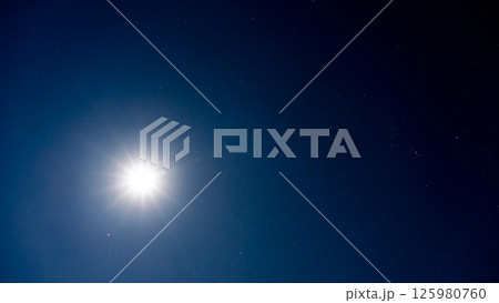 夜空を照らす月明かりと無数の輝く星 125980760