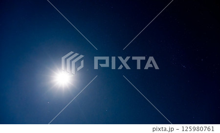 夜空を照らす月明かりと無数の輝く星 125980761