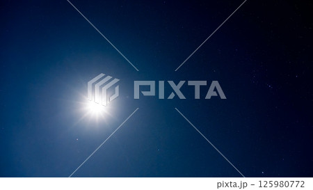 夜空を照らす月明かりと無数の輝く星 125980772