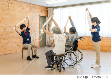 介護施設,デイサービスで体操,ストレッチをするシニア男女とスタッフの男女 介護施設,デイサービスで体操,ストレッチをするシニア男女とスタッフの男女 125980999