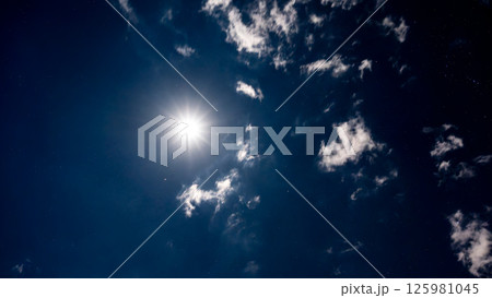 雲間に輝く満月と星空の夜空 125981045