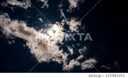 雲間に輝く満月と星空の夜空 125981051