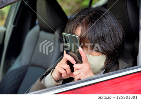 携帯電話のカメラで写真を撮る女性 携帯電話のカメラで写真を撮る女性 125981081