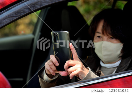 携帯電話のカメラで写真を撮る女性 携帯電話のカメラで写真を撮る女性 125981082