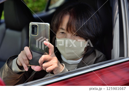 携帯電話のカメラで写真を撮る女性 携帯電話のカメラで写真を撮る女性 125981087
