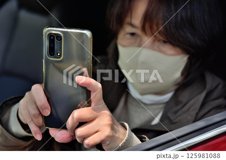 携帯電話のカメラで写真を撮る女性 携帯電話のカメラで写真を撮る女性 125981088