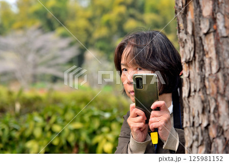 携帯電話のカメラで写真を撮る女性 125981152