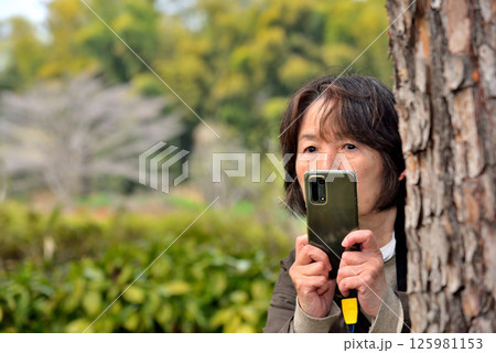 携帯電話のカメラで写真を撮る女性 125981153