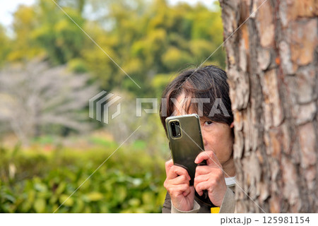 携帯電話のカメラで写真を撮る女性 携帯電話のカメラで写真を撮る女性 125981154
