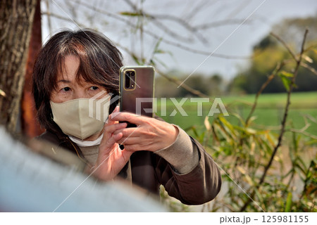 携帯電話のカメラで写真を撮る女性 携帯電話のカメラで写真を撮る女性 125981155