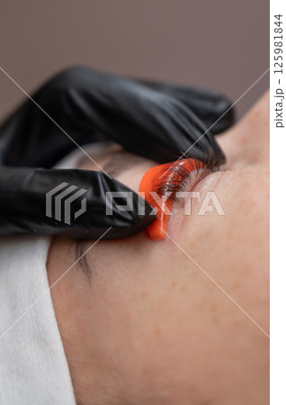Caucasian woman undergoing eyelash lamination procedure.  125981844