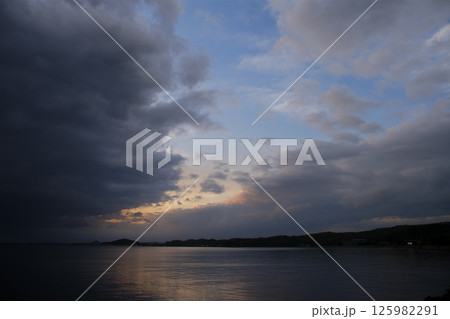 厚い雲に覆われた春の海 125982291