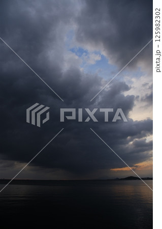 厚い雲に覆われた春の海 125982302