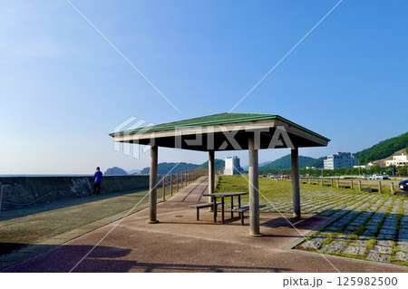 浅虫海づり公園駐車場の防波堤沿いの東屋がある風景　青森県青森市 125982500
