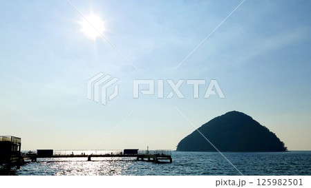 浅虫海づり公園の桟橋と湯の島の間の海面に夕陽が銀に帯をなす風景　青森県青森市 125982501