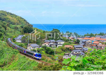 真っ青な日本海を望む高台から長和瀬の街並みと山陰本線を撮る 125983366