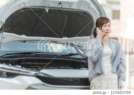 自動車の前でスマホで電話するアジア人女性(ロードサービス・トラブル・レスキュー・困る) 自動車の前でスマホで電話するアジア人女性(ロードサービス・トラブル・レスキュー・困る) 125983709