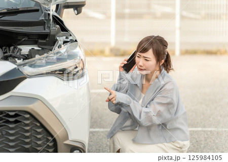 車をぶつけてスマホで電話する女性ドライバー（ロードサービス） 125984105