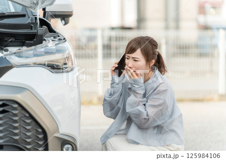 車をぶつけてスマホで電話する女性ドライバー（ロードサービス） 125984106