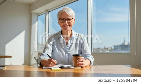 Smiling Senior Woman Working at Office Desk 125984204