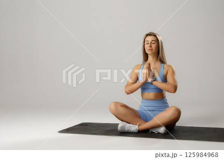 Young woman practicing yoga in a minimalistic studio during a peaceful meditation session 125984968