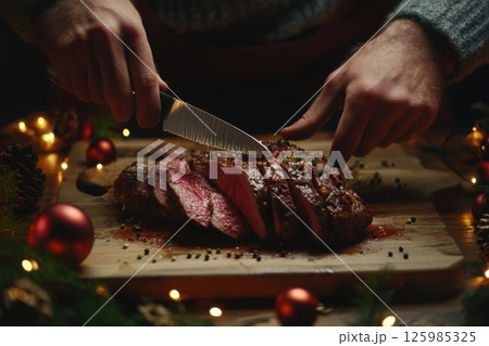 Holiday feast preparation with a roast being sliced on a wooden board during a festive gathering 125985325