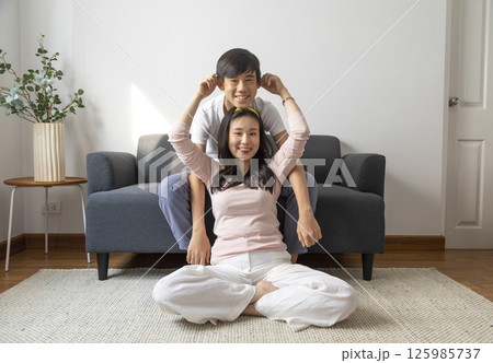 Laughing and hugging asian brother and sister with care and love on sofa at home. Laughing and hugging asian brother and sister with care and love on sofa at home. 125985737