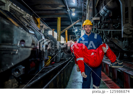 First aid support accident at work of worker at factory. Male worker has an accident on the floor in warehouse site. First aid support accident at work of worker at factory. Male worker has an accident on the floor in warehouse site. 125986874