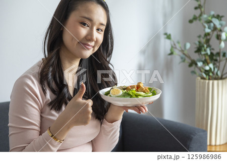 healthy eating, dieting and people concept - close up of young woman eating vegetable salad at home healthy eating, dieting and people concept - close up of young woman eating vegetable salad at home 125986986