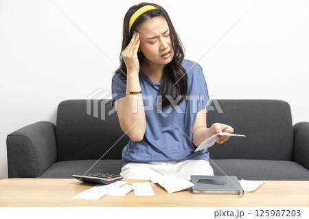 beautiful sad woman at home living room couch calculating monthly expenses worried in stress with bank papers and documents in paying taxes mortgage debt and cost of living concept beautiful sad woman at home living room couch calculating monthly expenses worried in stress with bank papers and documents in paying taxes mortgage debt and cost of living concept 125987203