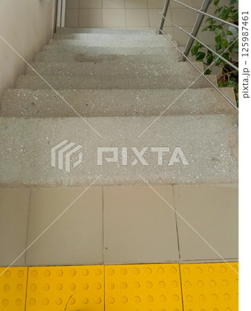 Steps leading to a lower level in a building with tactile paving for accessibility Steps leading to a lower level in a building with tactile paving for accessibility 125987461