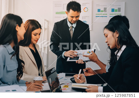 Team of financial advisory services. Asian advisor showing plan of investment to clients in the consultancy office. 125987851