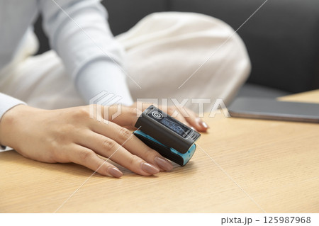 Pulse oximeter on womans left hand. Oxygen level and pulse measuring. Pulse oximeter on womans left hand. Oxygen level and pulse measuring. 125987968