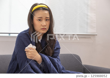 Sick woman lying in bed with high fever. Cold, flu, fever and migraine Sick woman lying in bed with high fever. Cold, flu, fever and migraine 125988052