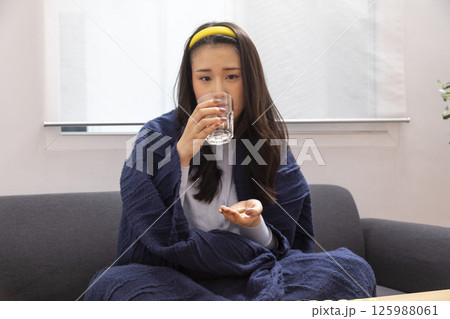 Sick woman lying in bed with high fever. Cold, flu, fever and migraine Sick woman lying in bed with high fever. Cold, flu, fever and migraine 125988061