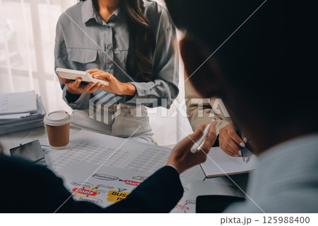 Team of financial advisory services. Asian advisor showing plan of investment to clients in the consultancy office. Team of financial advisory services. Asian advisor showing plan of investment to clients in the consultancy office. 125988400
