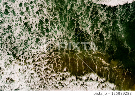 Aerial view Top down Waves crashing on sandy shore,Dark sea surface in summer day background,Seascape top view waves at Phuket Thailand 125989288