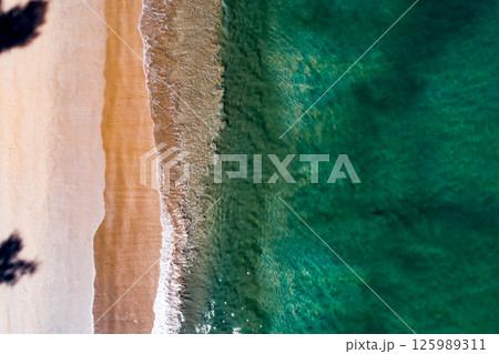 Aerial view Top down Waves crashing on sandy shore,Dark sea surface in summer day background,Seascape top view waves at Phuket Thailand 125989311