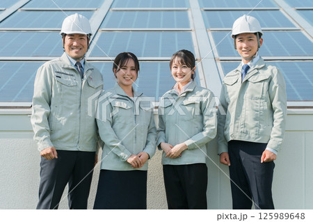 太陽光発電・ソーラーパネルの前に立つ電力会社・電気工事業者の作業着姿の技術者(クリーンエネルギー) 太陽光発電・ソーラーパネルの前に立つ電力会社・電気工事業者の作業着姿の技術者(クリーンエネルギー) 125989648