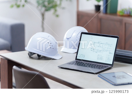オフィスにあるヘルメットとノートパソコン（無人） 125990173