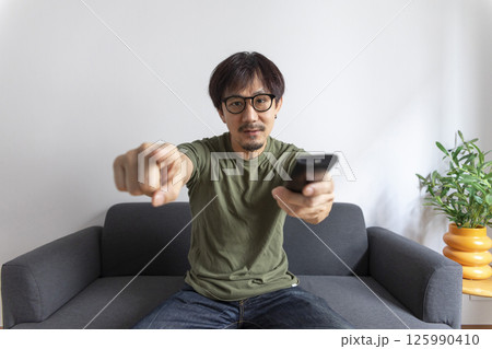 Man and hand with tv remote control Man and hand with tv remote control 125990410