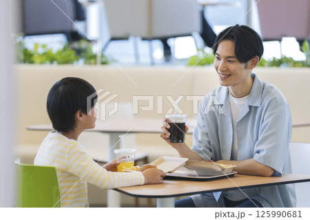 フードコードで食事をする親子　30代の父親と小学生の男の子 125990681