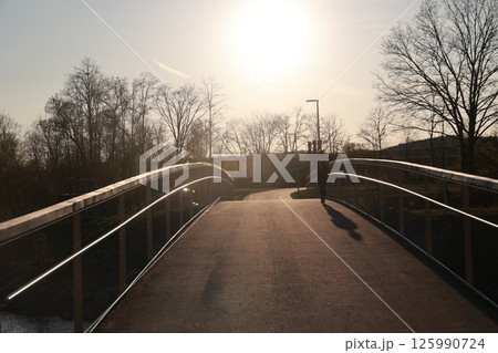 A bridge with a person walking across it A bridge with a person walking across it 125990724